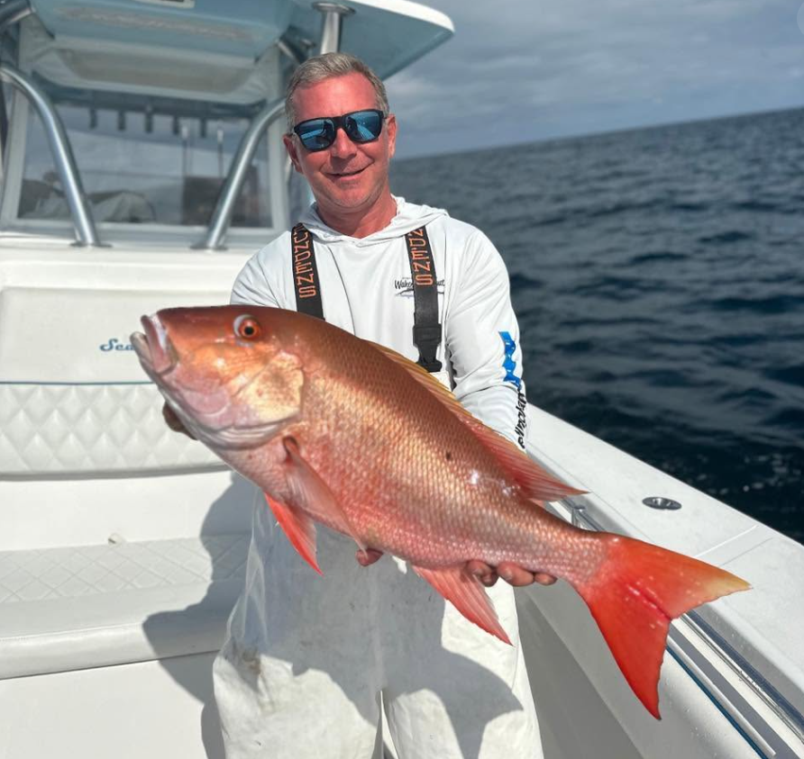 Darren Brett Conrad holding a fish on a boat